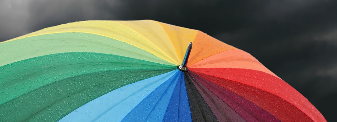 rainbow colored umbrella’s in heavy rain to use as background or cd cover