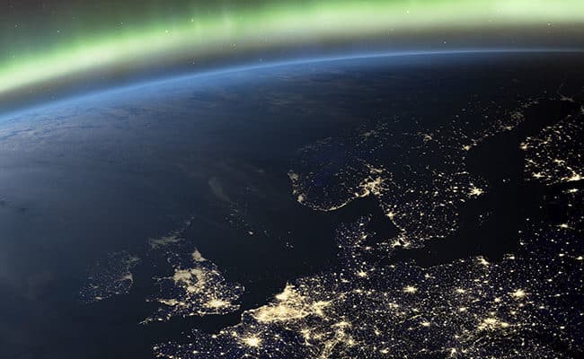 Planet Earth from the space at night and Northern Lights or Aurora Borealis related to the earth’s magnetic field. Europe at night viewed from space with city lights. Elements of this image furnished by NASA